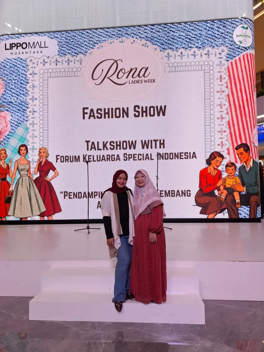 Dua orang berfoto di depan layar talkshow Forum Keluarga Spesial Indonesia di Lippo Mall Nusantara